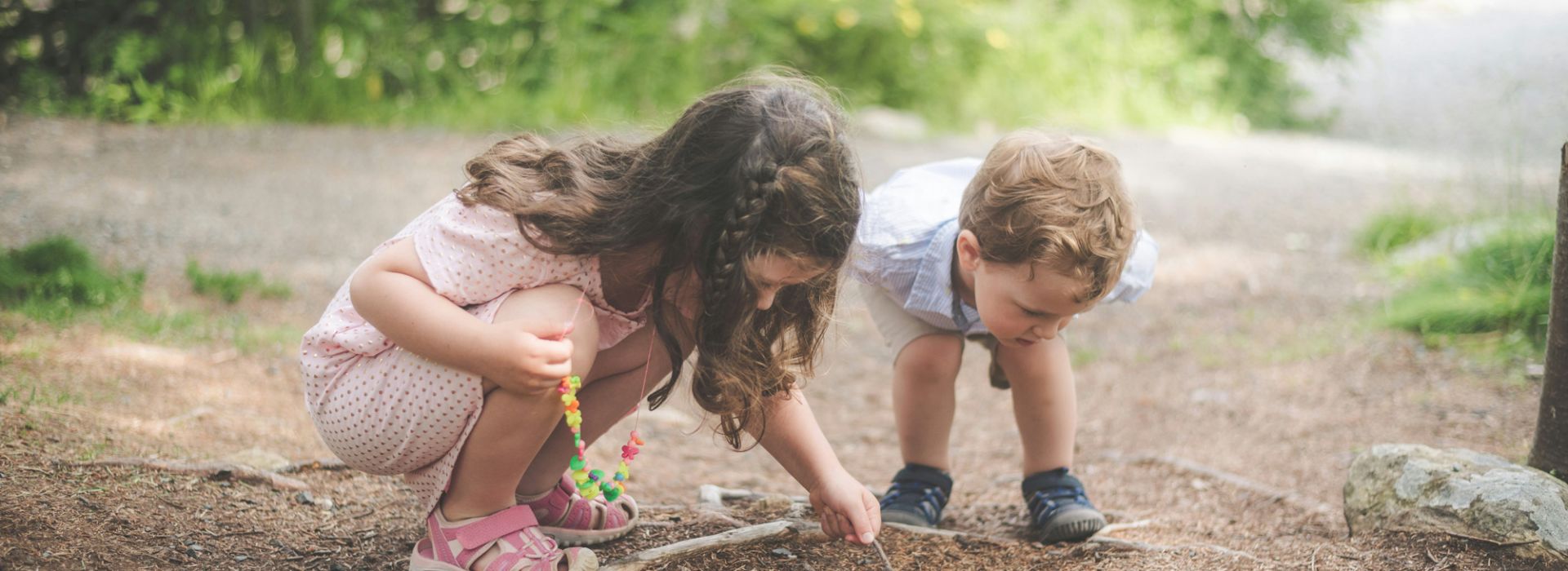 2 Kinder im Wald, die den Boden untersuchen